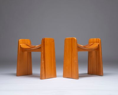 deux chaises en bois assises l'une à côté de l'autre sur une surface blanche