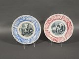two blue and white plates with a picture of a man and woman on them