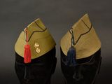 pair of military hats with tassels sitting on top of each other