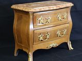 a small wooden chest of drawers on a black background