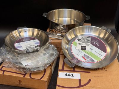 trois casseroles en acier inoxydable posées sur une boîte en carton