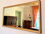 a large mirror hanging on the wall above a dresser