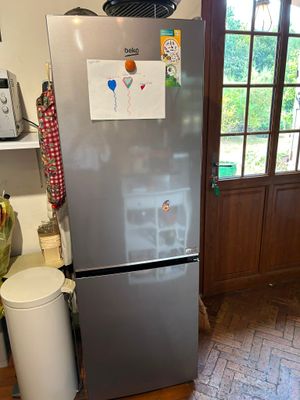 a refrigerator in the kitchen with a lot of magnets on it