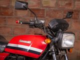 a red and black motorcycle parked in front of a brick wall