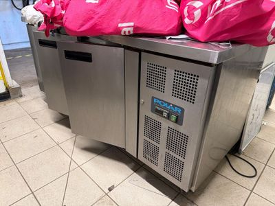 two freezers with bags on top of them on the floor