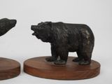 pair of black bears on wooden bases on a white background