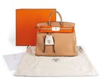 a brown and orange bag sitting on top of a white bag