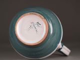 a close up of a teal and white cup with writing on it