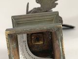 a small metal sculpture of a bird on top of a box