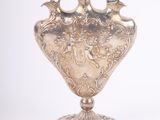 un vase en argent posé sur un socle, sur fond blanc