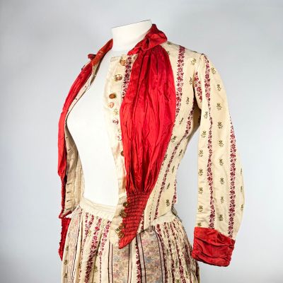 une image représentant une robe de femme ornée d'un foulard rouge