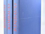 deux livres bleus posés l'un sur l'autre sur une surface blanche