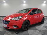une Opel rouge garée sur un sol à damier dans un garage