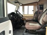 two seats in the back of a bus with a steering wheel