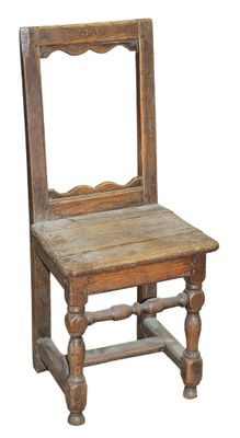 an old wooden chair sitting on top of a wooden table