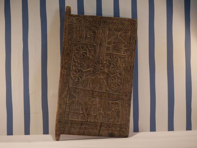 un mur rayé de bleu et de blanc, sur lequel se trouve une porte en bois
