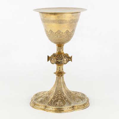 un calice ancien en laiton orné d'une croix sur le socle