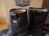 two pairs of black boots are on a shelf in a store