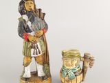 une figurine représentant un homme avec une pipe et un pot