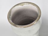a white vase with a brown rim on a white surface