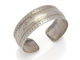 a close up of a silver cuff bracelet on a white background