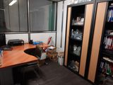 a room with a desk, a bookcase, and a computer monitor