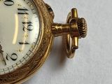 a close up of a gold pocket watch with roman numerals
