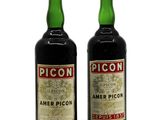 two bottles of liquor sitting next to each other on a white surface