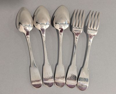 quatre cuillères et une fourchette en argent sur une surface blanche