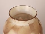 a brown and white vase sitting on a table