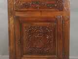 une vieille armoire en bois dont les portes et les tiroirs sont sculptés