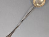 an antique silver spoon with a spoon handle and a spoon in the middle of it