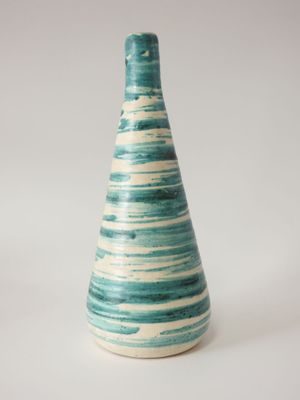 un vase bleu et blanc posé sur une surface blanche