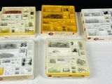 quatre boîtes contenant des articles variés, posées sur une table devant un fond noir