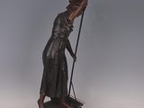 a bronze statue of a woman holding a spear on a pedestal