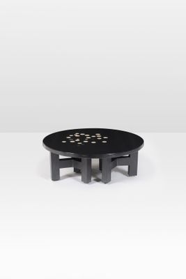 une table basse noire avec des pois dorés sur le plateau