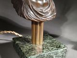 bronze bust of a woman with wings on a green marble base