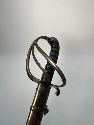 a close up of a sword with a metal handle on a table