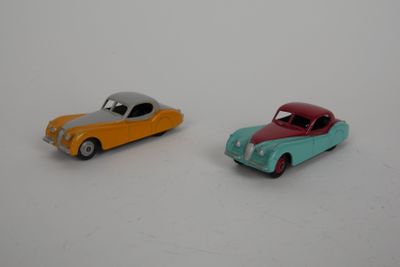 deux voitures jouets assises l'une à côté de l'autre sur une surface blanche