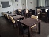 tables and chairs in a room with a fireplace in the background