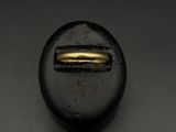 un gros plan sur un bouton noir orné d'un anneau doré