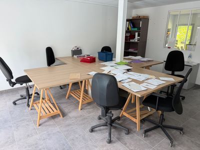 plusieurs chaises disposées autour d'une table sur laquelle se trouvent des papiers