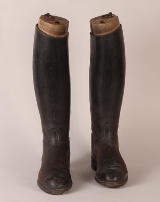 pair of black leather riding boots on a white background