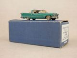 une petite voiture verte posée sur une boîte bleue