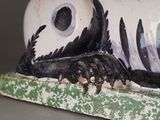 a ceramic sculpture of a cat laying down on a table