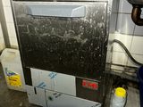 a dirty dishwasher in a dirty kitchen next to a trash can