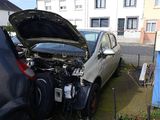 a car with its hood open sitting on the side of the road