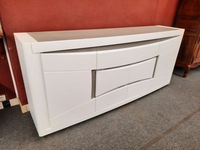 un gros plan sur une armoire blanche à tiroirs devant un mur rouge