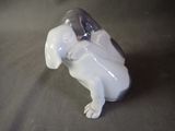 a white dog figurine sitting on a table