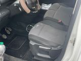 the interior of a small car with a steering wheel and a phone in the passenger seat